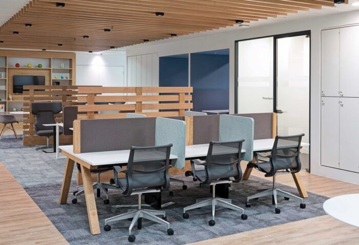 Zee Bench Desk double sided 6 person desk with desktop screens shown with task chairs in an office space